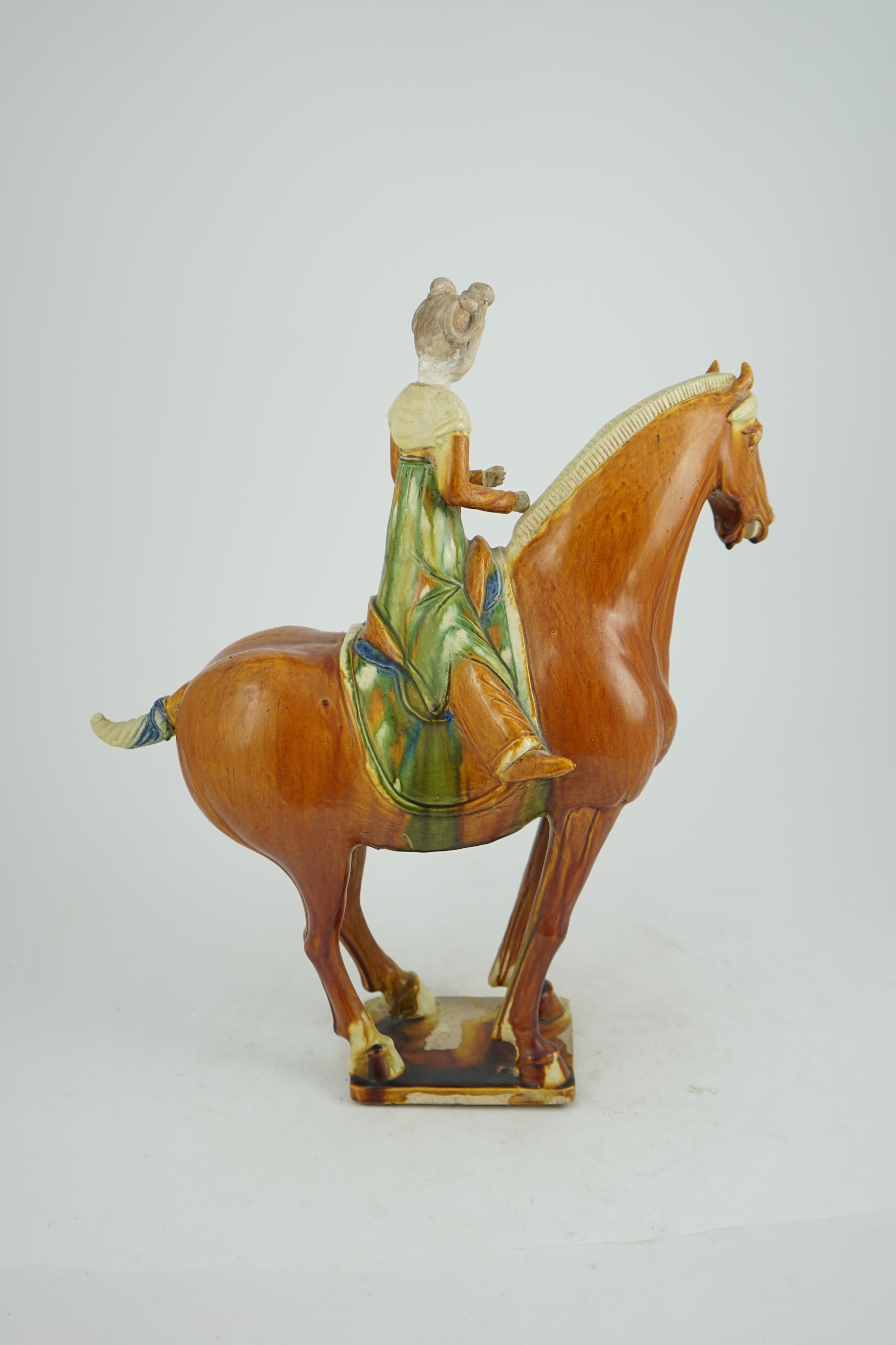 A Chinese sancai glazed group of a horse and female rider, Tang or later